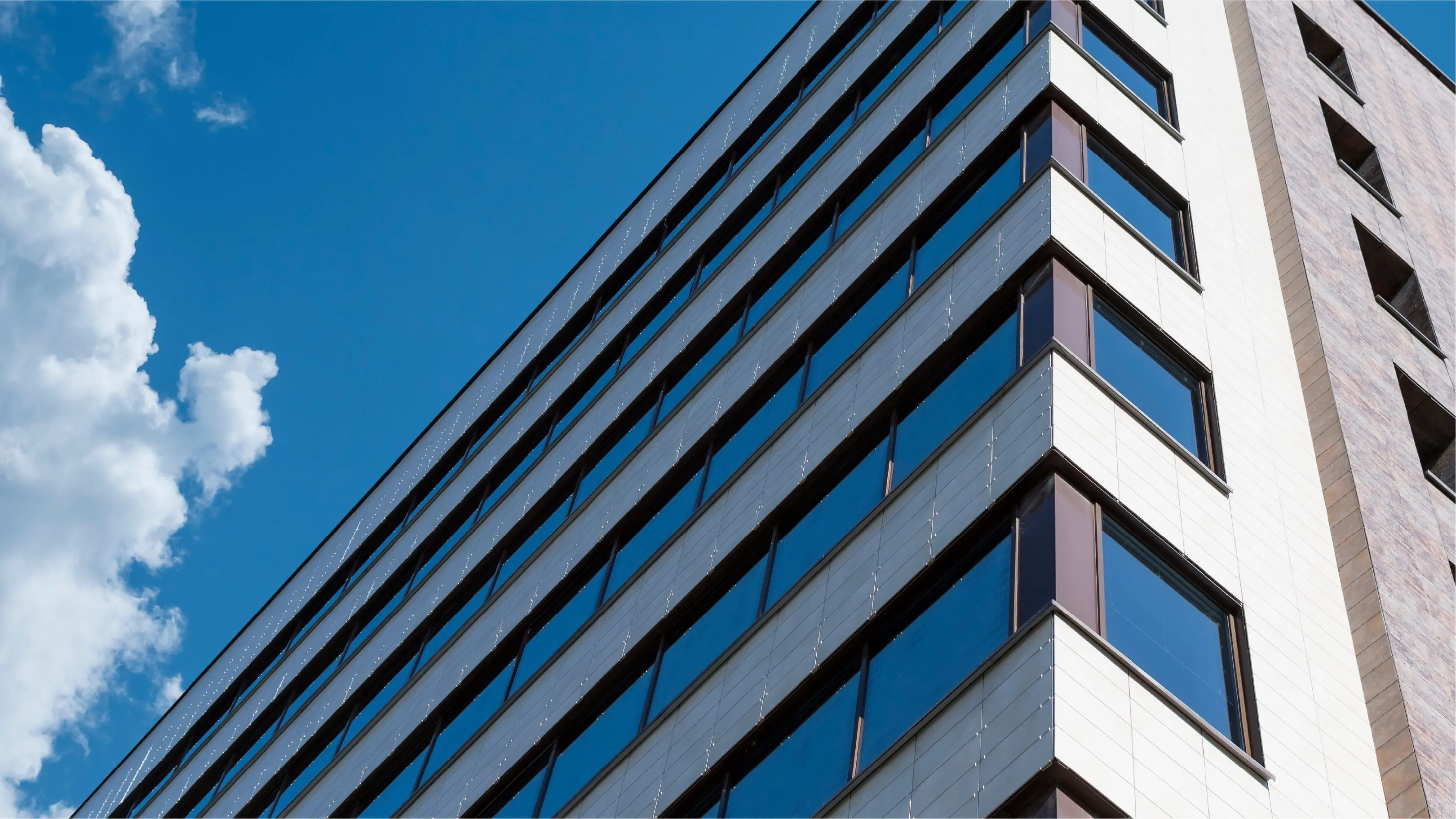 ヘルメットを着用した作業員2人が、配管が張り巡らされた大規模な工場設備内で上方を指差し、設備点検や確認を行っている様子