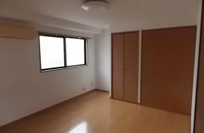 フローリング床の洋室で、窓から自然光が入り、右側に木製扉のクローゼットが並ぶシンプルな室内